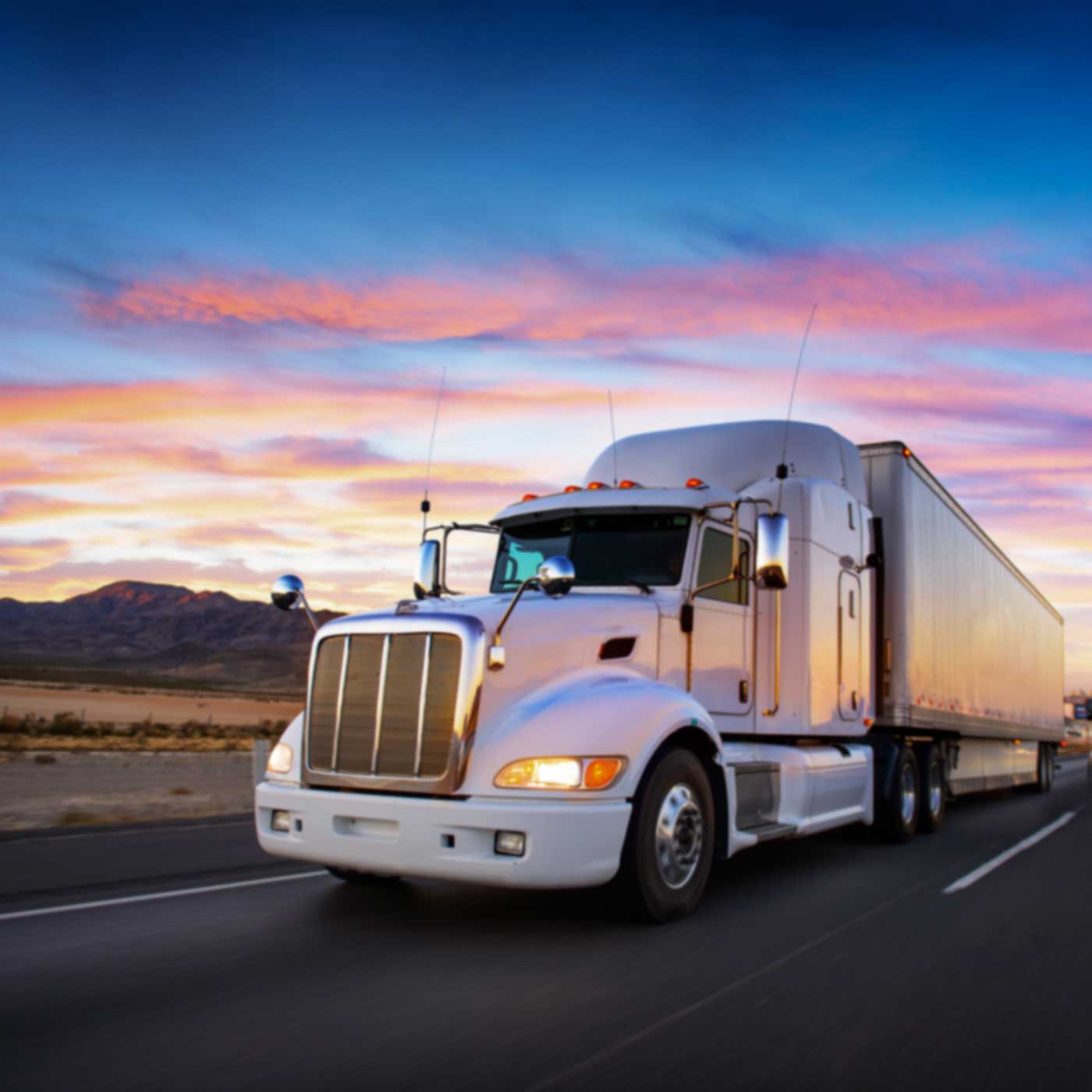 freight moving down 4-lane highway through mojave desert